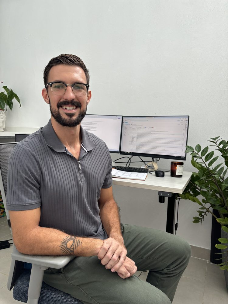 Lucas, founder of Bridge Language Coaching, smiling at his desk